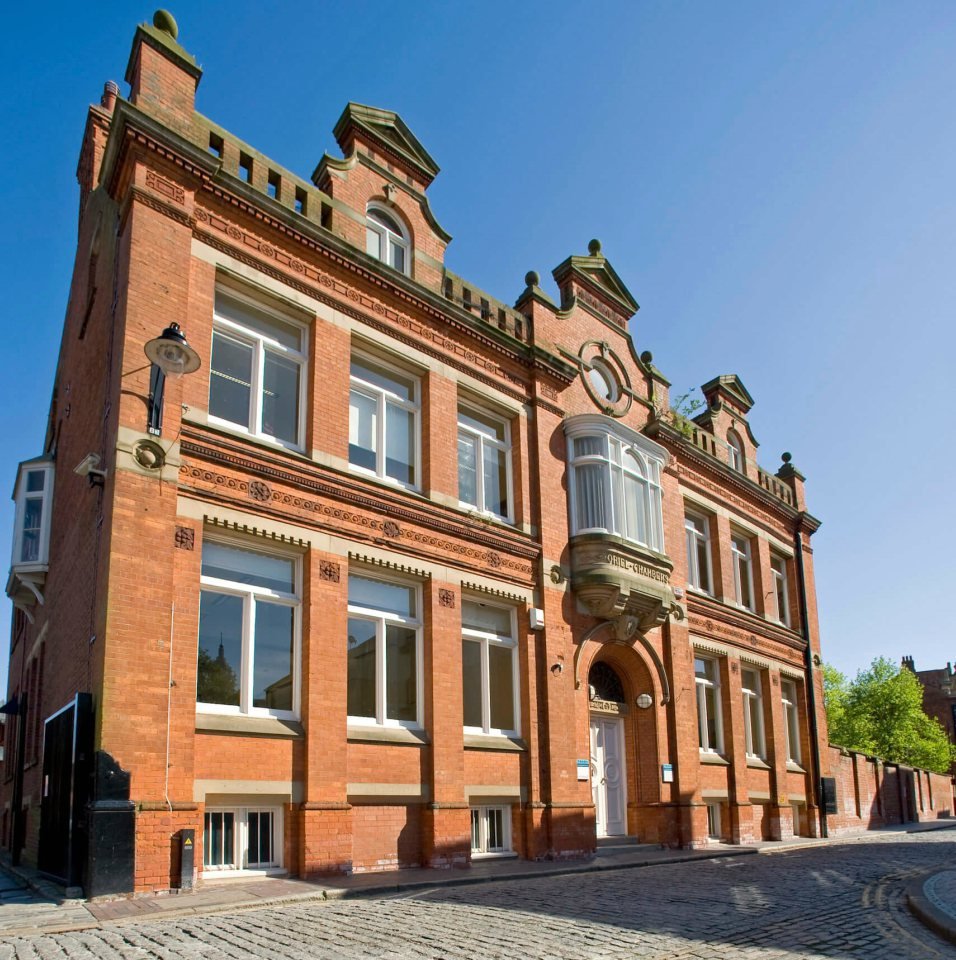 Fachada de edificio histórico de ladrillo rojo con detalles victorianos
