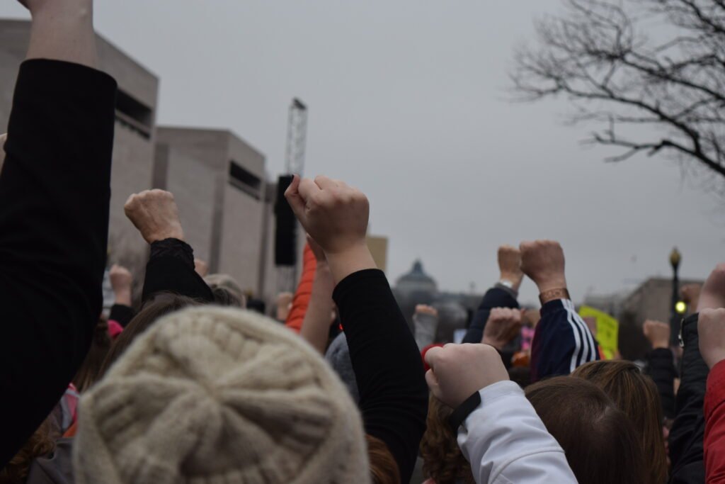 Personas alzando los puños durante una manifestación urbana